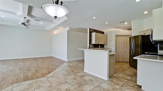 kitchen with hanging light fixtures, black refrigerator with ice dispenser, sink, and ceiling fan