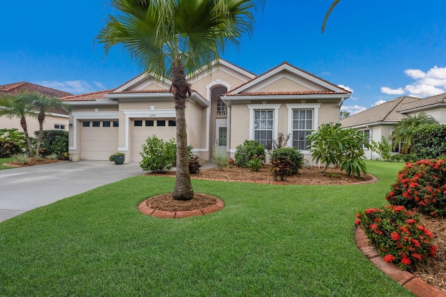 mediterranean / spanish house featuring stucco siding, concrete driveway, an attached garage, a front yard, and a tiled roof