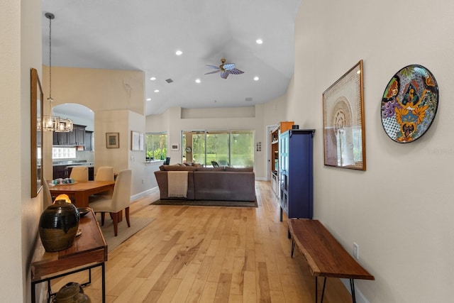 interior space with arched walkways, recessed lighting, baseboards, light wood-style floors, and an inviting chandelier