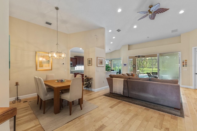 dining room with light wood-style flooring, visible vents, and ceiling fan with notable chandelier