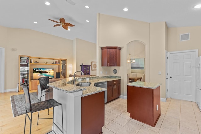 kitchen with light stone counters, a peninsula, a sink, visible vents, and dishwasher