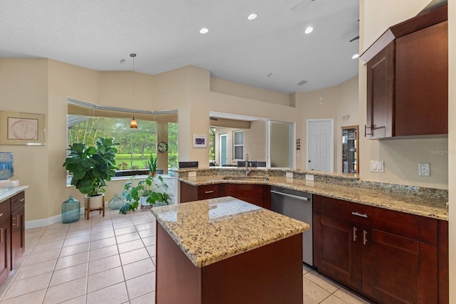 kitchen featuring dishwasher, a kitchen island, a peninsula, light stone countertops, and a sink