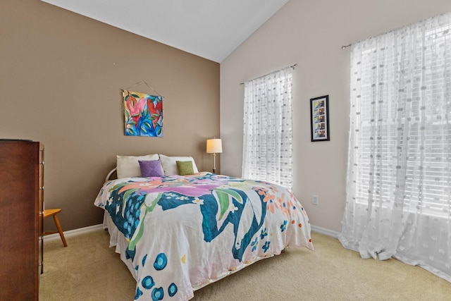 bedroom with light carpet, multiple windows, and vaulted ceiling