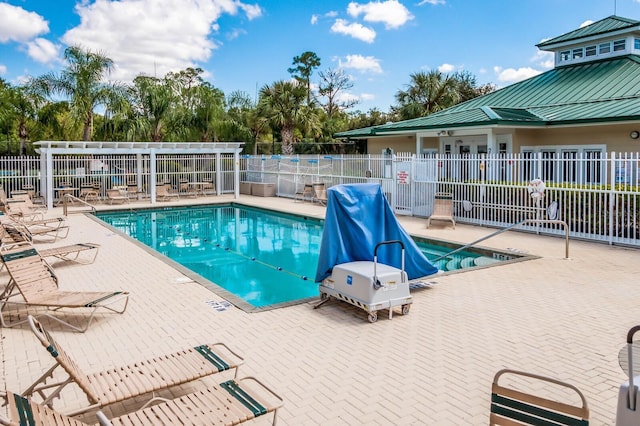 community pool with a patio area and fence