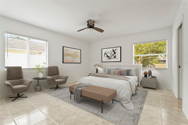 bedroom with a ceiling fan, light tile patterned flooring, and multiple windows
