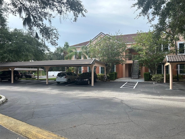 covered parking lot featuring stairway