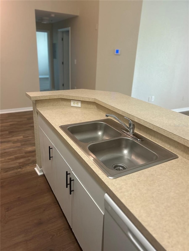 kitchen with white cabinets, sink, dark hardwood / wood-style floors, and stainless steel dishwasher