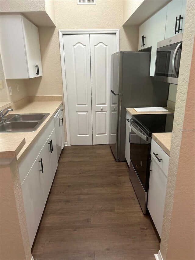 kitchen with white cabinets, dark wood-type flooring, stainless steel appliances, and sink