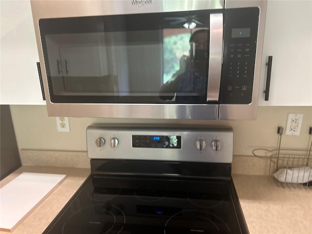 room details featuring white cabinets and stainless steel appliances