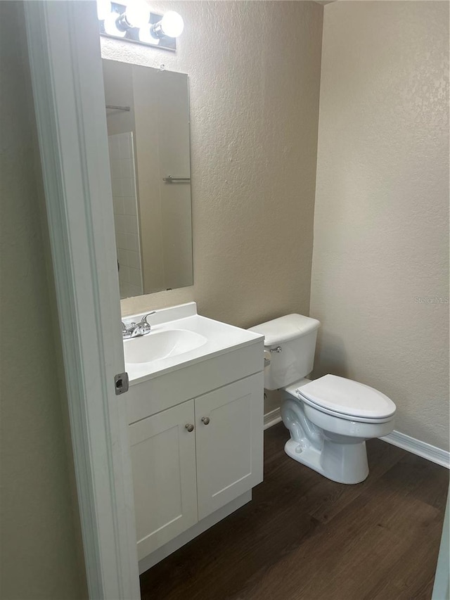 bathroom featuring hardwood / wood-style flooring, vanity, and toilet