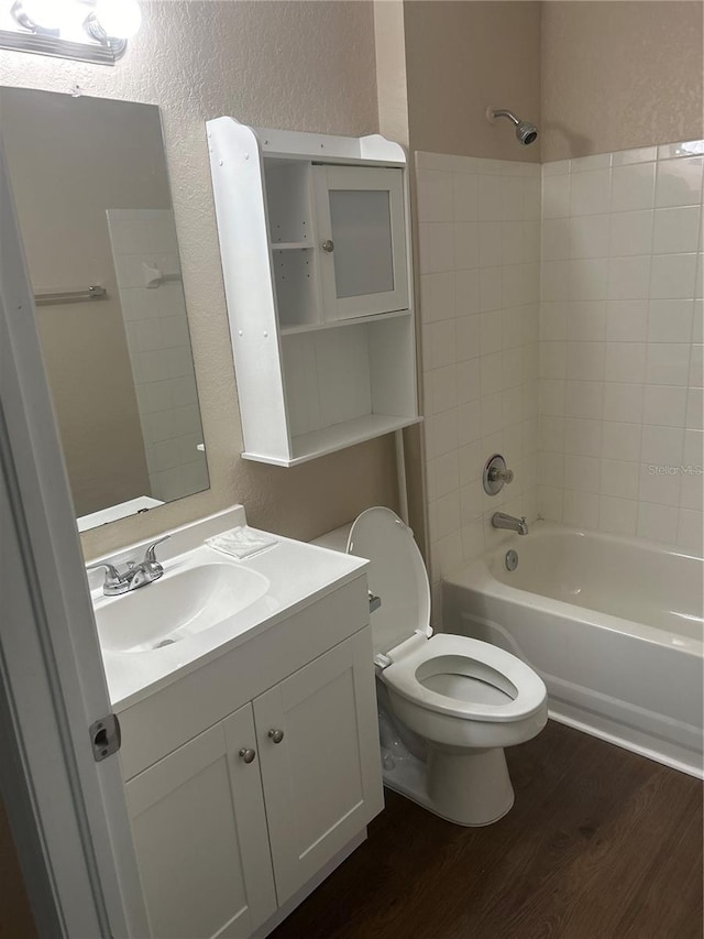 full bathroom featuring vanity, toilet, hardwood / wood-style floors, and tiled shower / bath