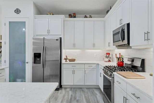 kitchen featuring stainless steel appliances, light hardwood / wood-style floors, and white cabinets