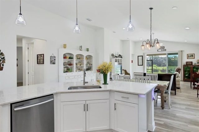 kitchen featuring sink, dishwasher, white cabinets, and vaulted ceiling