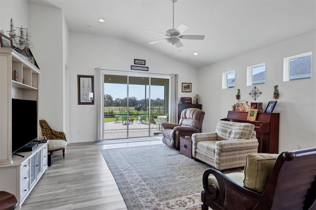 living room featuring light wood-type flooring, ceiling fan, and lofted ceiling