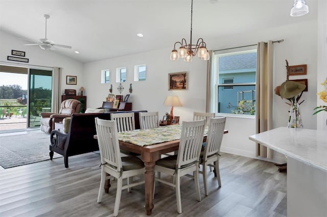 dining room featuring vaulted ceiling, ceiling fan with notable chandelier, and hardwood / wood-style floors