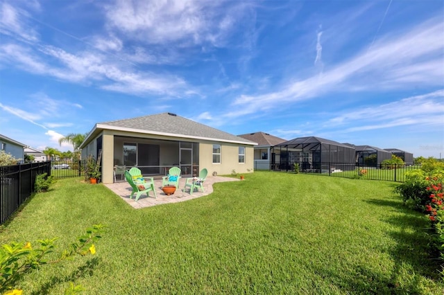 back of house with a yard, a sunroom, a patio area, and glass enclosure