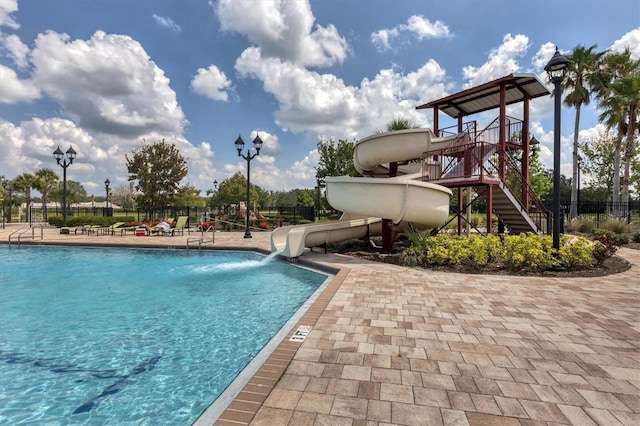 view of pool featuring a water slide and a playground