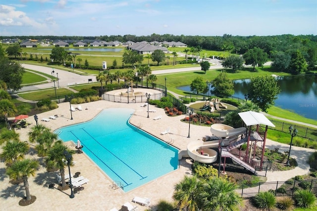 view of swimming pool featuring a water slide, a patio area, and a water view