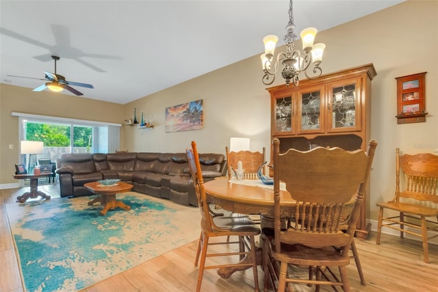 dining area with ceiling fan with notable chandelier and light hardwood / wood-style floors