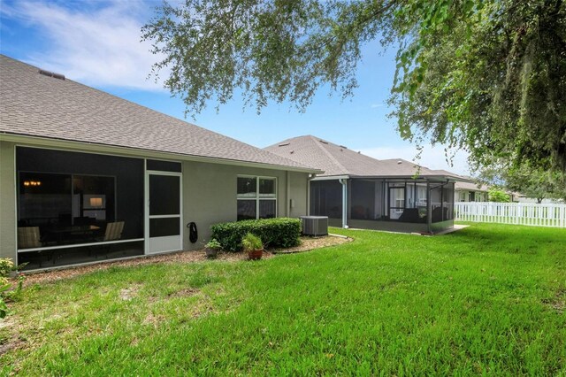 back of house with a sunroom, central AC unit, and a yard