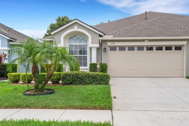 single story home with a garage and a front lawn