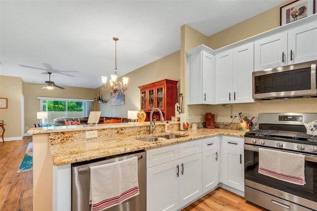 kitchen featuring light wood-type flooring, appliances with stainless steel finishes, sink, and kitchen peninsula