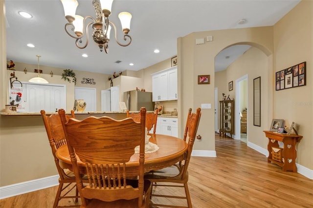 dining room with light wood-type flooring and a chandelier