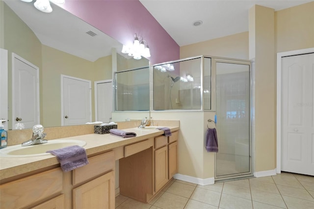 bathroom with dual bowl vanity, tile patterned flooring, and a shower with shower door