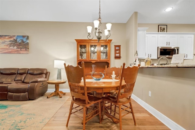 dining room featuring light hardwood / wood-style flooring and a chandelier