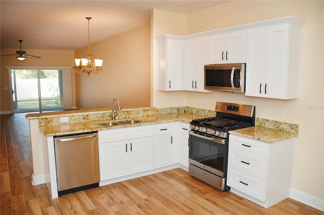 kitchen featuring pendant lighting, sink, white cabinets, kitchen peninsula, and stainless steel appliances