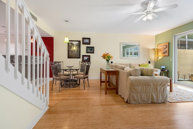 living room featuring ceiling fan and light hardwood / wood-style flooring