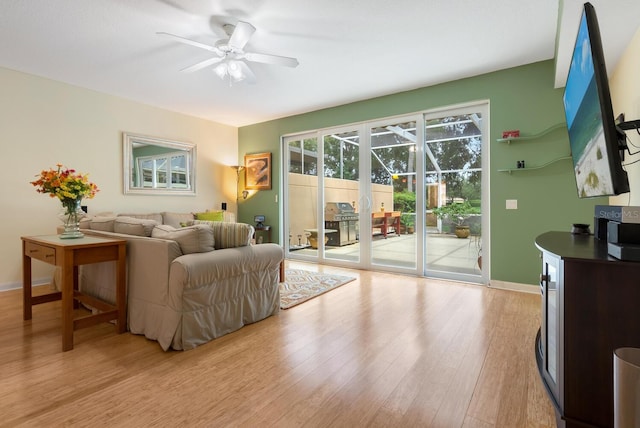 living room featuring ceiling fan and light hardwood / wood-style flooring