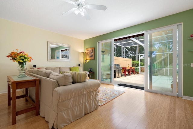 living room with ceiling fan and light hardwood / wood-style flooring