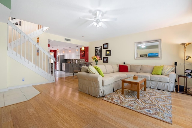 living room featuring ceiling fan and light hardwood / wood-style flooring