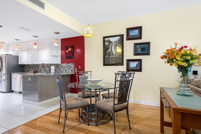 dining area featuring sink and light hardwood / wood-style floors