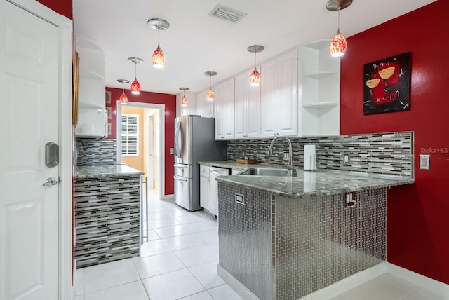 kitchen with white cabinets, hanging light fixtures, light tile patterned floors, tasteful backsplash, and sink