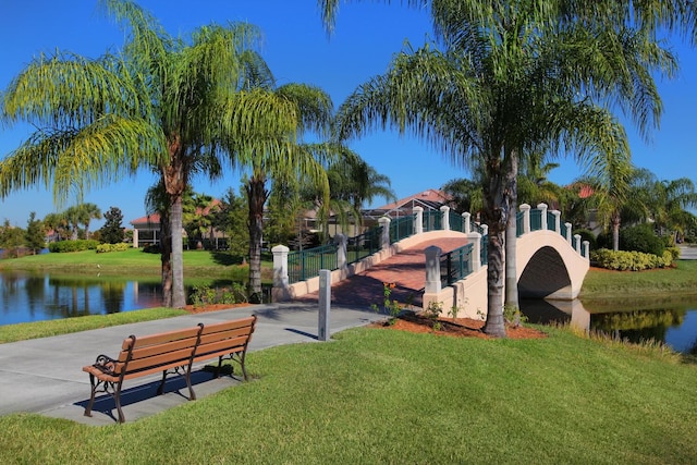 surrounding community with a lawn and a water view