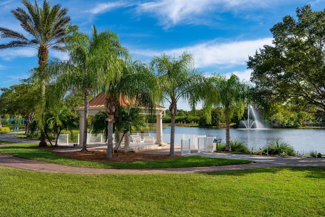 view of property's community featuring a lawn and a water view