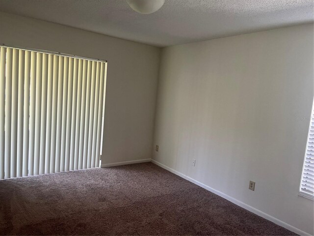 carpeted spare room featuring a textured ceiling