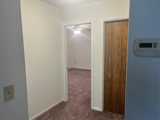 hallway featuring dark colored carpet