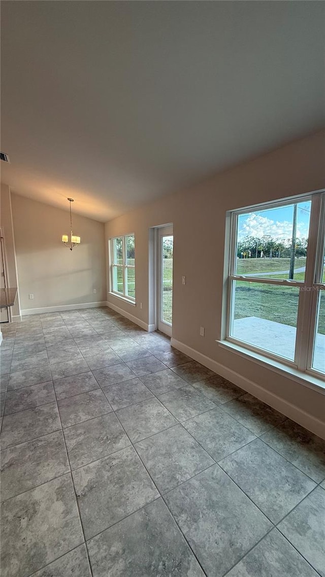 empty room featuring lofted ceiling and a notable chandelier