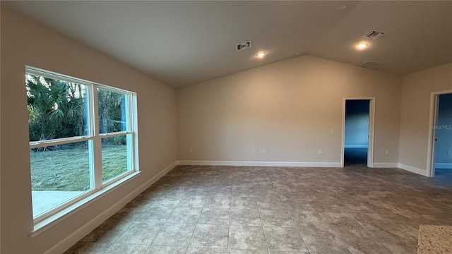 spare room featuring lofted ceiling and a wealth of natural light