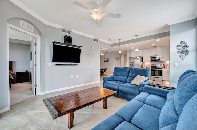 tiled living room with ornamental molding and ceiling fan