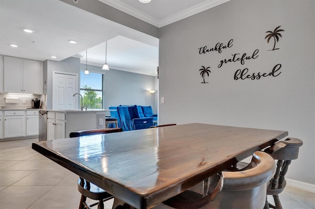 tiled dining room with sink and crown molding