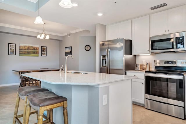 kitchen featuring decorative light fixtures, white cabinetry, sink, a kitchen island with sink, and stainless steel appliances