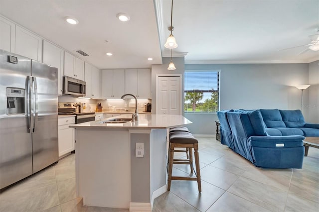 kitchen featuring white cabinetry, appliances with stainless steel finishes, sink, and hanging light fixtures