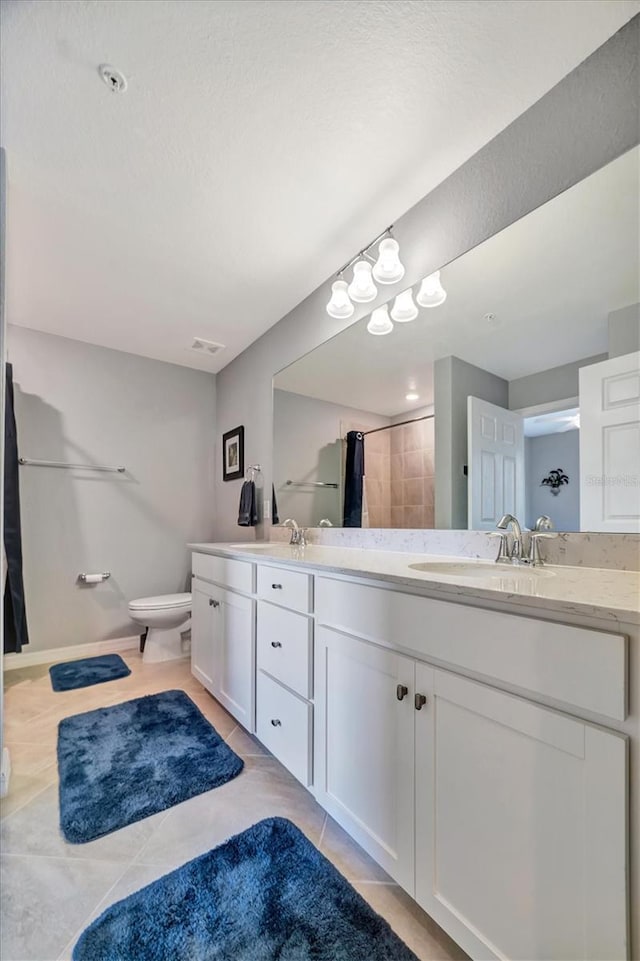 bathroom featuring vanity, walk in shower, tile patterned floors, and toilet