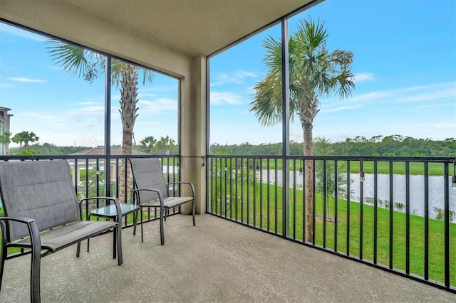 sunroom featuring a water view