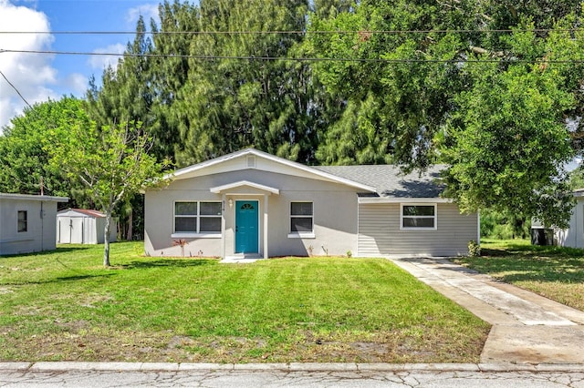 view of front of property with a front yard and a storage shed