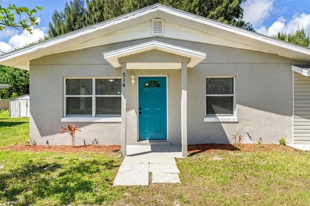 view of exterior entry featuring a lawn